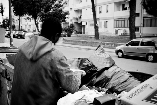 Un uomo cerca tra i rifiuti