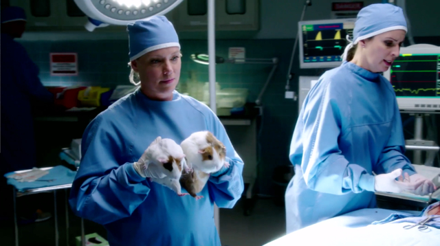 Dori passes a Guinea Pig Defibrillator to Doctor Beth, attempting to sabotage the operation.