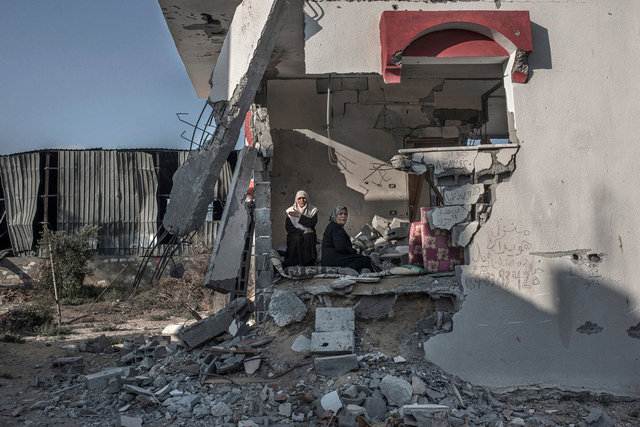 Two women in their destroyed house reading the Koran. Rafah. Gaza Strip