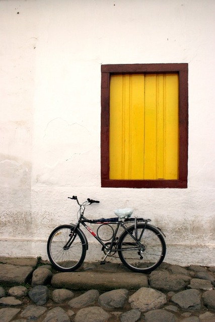 Fachada com janela amarela e bicicleta