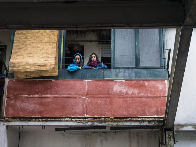 Due bambine affacciate al balcone nelle vele di Scampia